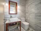 Modern bathroom with marble walls and a rectangular mirror