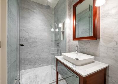 Modern bathroom with marble walls and glass shower