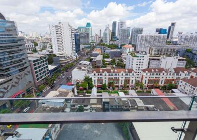 View from balcony overlooking city with tall buildings and residential area