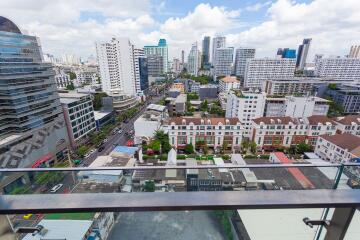 View from balcony overlooking city with tall buildings and residential area