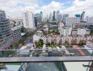 View from balcony overlooking city with tall buildings and residential area