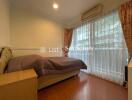 Cozy bedroom with a large window and wooden flooring