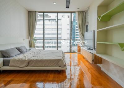 Modern bedroom with large windows and hardwood flooring