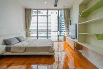 Modern bedroom with large windows and hardwood flooring