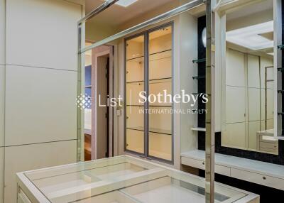 Well-lit walk-in closet with a glass display island