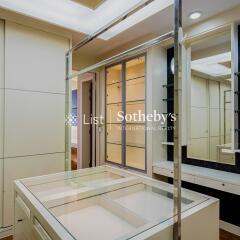 Well-lit walk-in closet with a glass display island