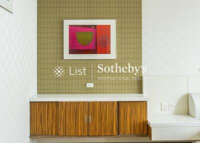 Modern living area with wooden flooring, wall art, and built-in cabinetry