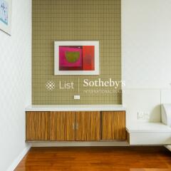 Modern living area with wooden flooring, wall art, and built-in cabinetry