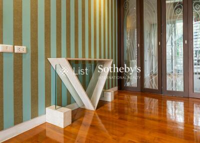 Elegant hallway with striped wallpaper and unique V-shaped glass table