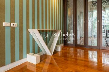 Elegant hallway with striped wallpaper and unique V-shaped glass table