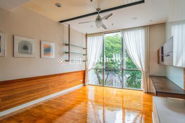 Spacious living room with large windows and wooden flooring