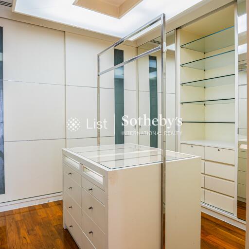 Modern walk-in closet with ample storage and island dresser