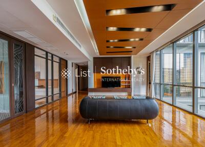 Spacious modern living room with wooden flooring, ceiling design, and large windows