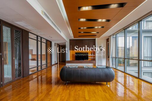 Spacious modern living room with wooden flooring, ceiling design, and large windows