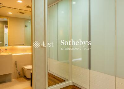 Bathroom and walk-in closet area with mirror and lighting