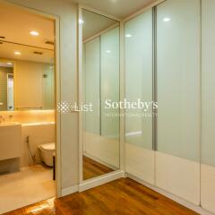 Bathroom and walk-in closet area with mirror and lighting