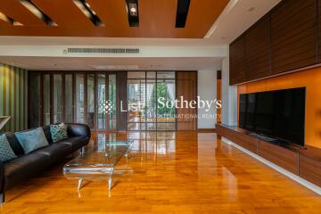 Spacious and modern living room with sleek furniture and a large TV