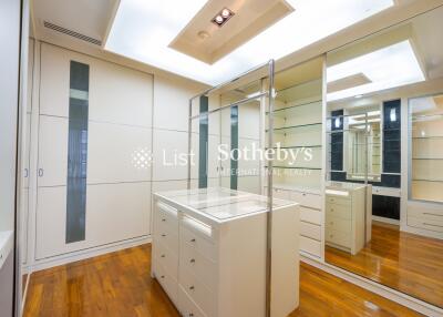 Walk-in closet with wooden floors and mirrored cabinets