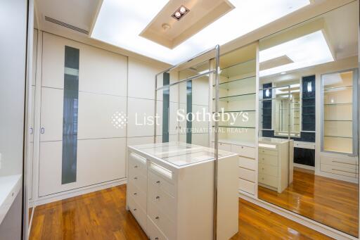 Walk-in closet with wooden floors and mirrored cabinets