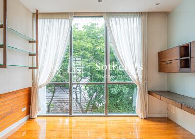 Bright living room with large windows and built-in shelves and drawers