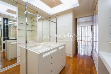 Spacious walk-in closet with ample storage and glass shelving