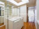 Spacious walk-in closet with ample storage and glass shelving