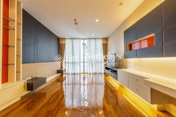 Modern living room with wooden floors, large window with curtains, built-in cabinets and shelves, and stylish lighting