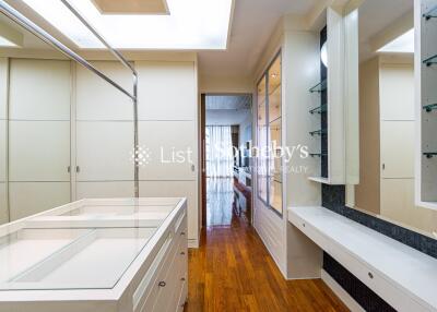 Spacious walk-in closet with built-in storage and hardwood floors