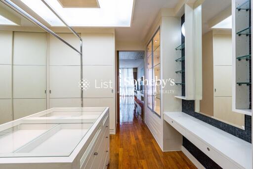 Spacious walk-in closet with built-in storage and hardwood floors