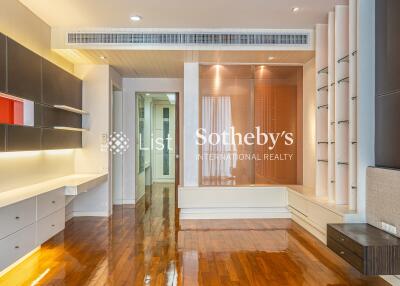 Modern living room with wooden floor, built-in shelves, and recessed lighting