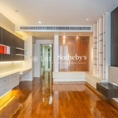 Modern living room with wooden floor, built-in shelves, and recessed lighting