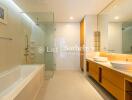 Modern and spacious bathroom with glass shower and dual sinks