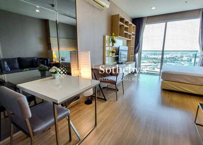 Modern living area with dining table, sofa, TV, and large window