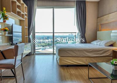 Spacious bedroom with work area and city view