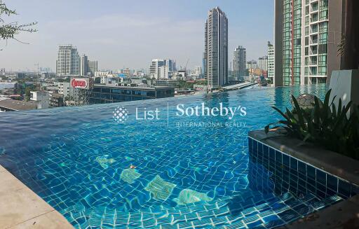 High-rise building with rooftop infinity pool and city view