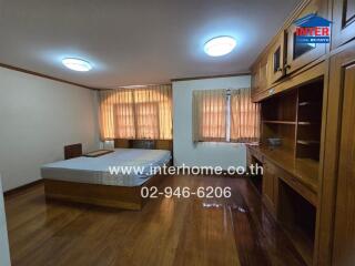 Spacious bedroom with wooden furniture and large windows