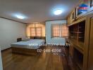 Spacious bedroom with wooden furniture and large windows