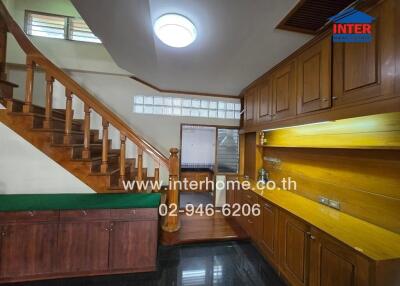 Main living space with wooden staircase and built-in cabinetry