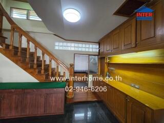 Main living space with wooden staircase and built-in cabinetry