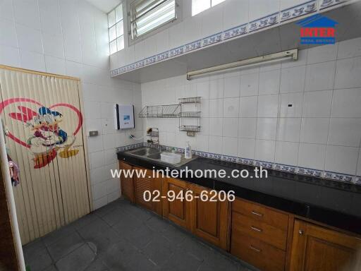 Clean kitchen area with counter, sink, and storage space