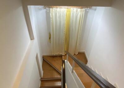 Staircase with wooden steps and a window with curtains