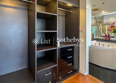 Spacious walk-in closet with built-in shelves and drawers, adjacent to luxurious bathroom