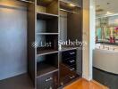 Spacious walk-in closet with built-in shelves and drawers, adjacent to luxurious bathroom