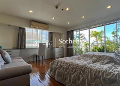 Spacious bedroom with large windows and greenery views