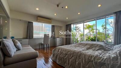 Spacious bedroom with large windows and greenery views