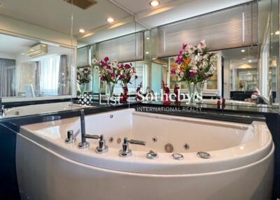 Modern bathroom with large bathtub and decorative flowers