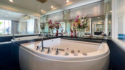 Modern bathroom with large bathtub and decorative flowers