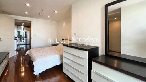 Modern bedroom with wooden flooring and white furniture