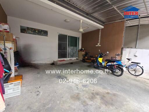 Garage space with shelves, bicycles, and a scooter