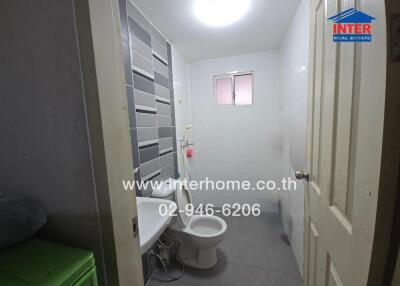 Modern bathroom with toilet, shower, and tiled walls